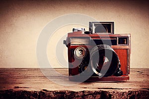 Vintage camera on a wooden table, vintage colors and atmosphere.