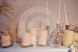 Vintage candles in a candlestick and flowers on the shelf, close-up