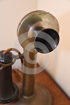 Vintage candlestick telephone on a wooden desk