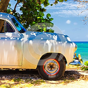 Vintage car at a beach in Cuba