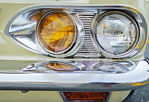 Vintage Car Front Detail. Classic car headlights close-up. Headlights of yellow vintage car. Exhibition