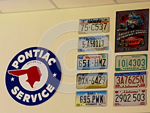 Vintage car license plates from different USA states hanging on the wall