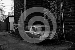 Vintage car near the wooden hause in Tomsk, Siberia.