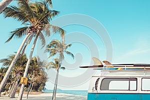 Vintage car parked on the tropical beach seaside with a surfboard on the roof