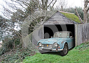 Vintage car triumph tr4 found in derelict abandoned shed garage photo