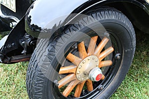 A vintage car wheel with wooden spokes