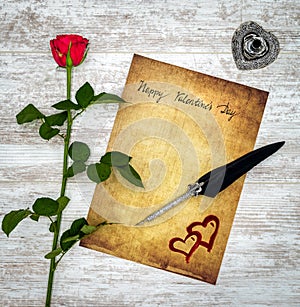 Vintage card with red rose, painted harts, ink and quill on white painted oak - top view