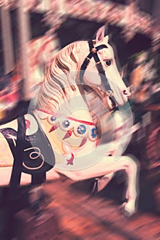 Vintage carousel horse. Antique style carved wood on an old amusement merry go round motion blur