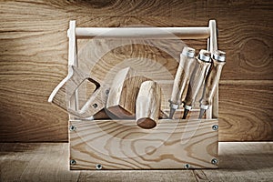 Vintage carpenter tools in wooden box on wood background