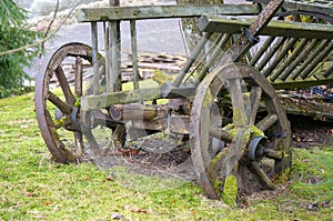 Vintage cart. Damaged.antique transport.Retro cart standing on the lawn. Dray in grass. Old.