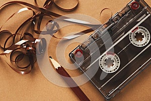 Vintage cassette and pencil to rewind tape on brown background