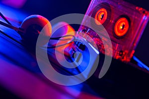 Vintage cassette tape player in neon light. 80s - 90s advertisement style. Disco party nostalgy concept photo