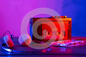 Vintage cassette tape player in neon light. 80s - 90s advertisement style. Disco party nostalgy concept photo