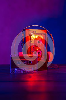 Vintage cassette tape player in neon light. 80s - 90s advertisement style. Disco party nostalgy concept photo