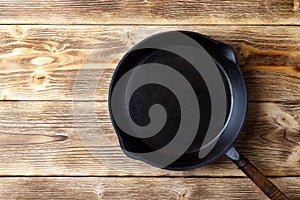 Vintage cast iron pan on wooden rustic background. Top view.