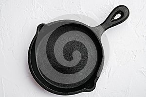 Vintage cast iron skillet with copy space for text or food with copy space for text or food, top view flat lay , on white stone