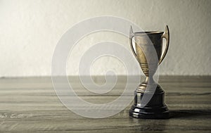 vintage champion golden trophy placed on wooden table