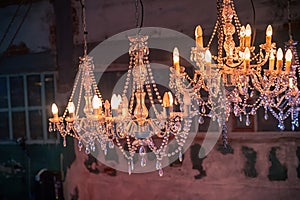 Vintage chandeliers on the background of old walls and Windows. The old interior of the room.