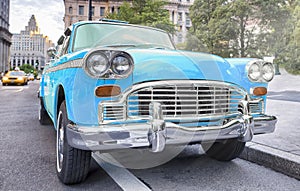 Vintage chequered blue taxi cab in New York City. Manhattan street traffic