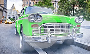 Vintage chequered green taxi cab in New York City. Manhattan street traffic