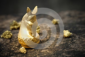 Vintage chess horse in gold and gold on old stone floor