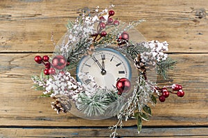 Vintage Christmas clock with frame of Christmas wreath on a black background. Copy space, place for text with Christmas clock