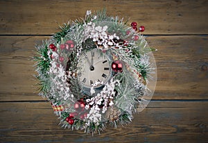 Vintage Christmas clock with frame of Christmas wreath on a black background. Copy space, place for text with Christmas clock