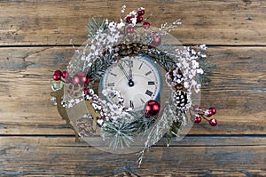 Vintage Christmas clock with frame of Christmas wreath on a black background. Copy space, place for text with Christmas clock