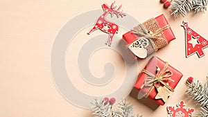 Vintage Christmas flat lay composition. Beige Xmas background with handmade Christmas decorations, red gift boxes and pine tree