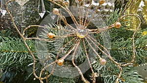 Vintage Christmas ornaments. Decorative flower made from golden wire. Fir tree, shiny silver and golden baubles background. Tradit