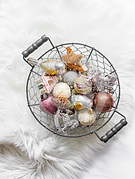 Vintage Christmas toys in a metal basket on a fluffy carpet, top view