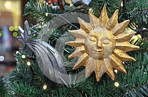 Vintage Christmas toys sun and star made of papier-mache on Christmas tree with a garland