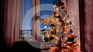 Vintage Christmas tree and toy owl on window sill at night. Christmas eve. Xmas decor at home. Soft focus. Film grain