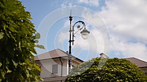 Vintage city park street lamp with shattered glass. Stylized old fashioned outdoor lantern with LED lamp on sunny day in