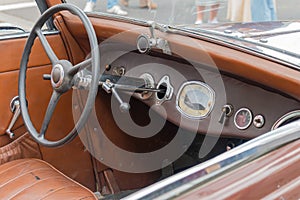 Vintage classic car dashboard with leather interior and retro steering wheel