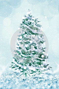 Vintage classic Christmas tree with white ornaments, shiny lights, white snow and bokeh background holiday greeting card