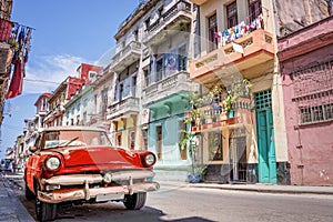 Vintage classic red american car in a colorful street of Havana Cuba