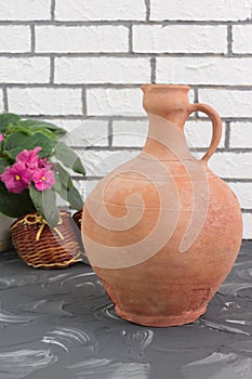 Vintage clay jug in  home interior. Handmade brown old vessel