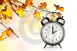 Vintage clock and autumn colors leaves Fall daylight savings time change concept