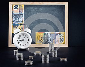 Vintage clock, blackboard, 50 australian dollars bill, and coin