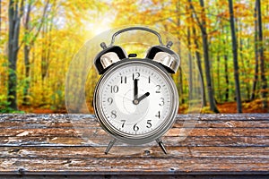 Vintage clock in a forest in autumn Fall daylight savings time change concept