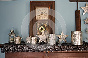 large wooden clock with tin christmas ornaments on a mantel