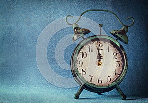 Vintage clock over blue ice bokeh background. new year concept. selective focus