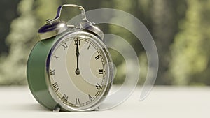 Vintage clock showing twelve of clock on blurred background