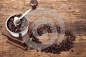 Vintage coffee bean grinder next to circle shape coffee beans