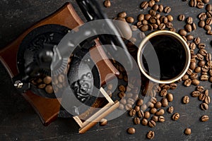 Vintage coffee grinder with coffee cup. Manual coffee grinder for grinding coffee beans on dank background.