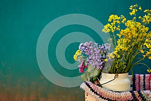 Vintage colorful yellow watering can with handmade rug. Country life, cottage core, creative rustic patchwork concept