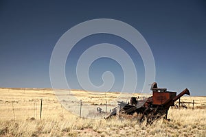 Vintage combine harvester and old field