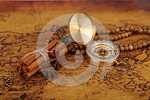 Vintage compass and cinnamon spices on a old world map - trade and explorer concept