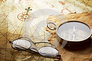 Vintage compass and glasses on antique map